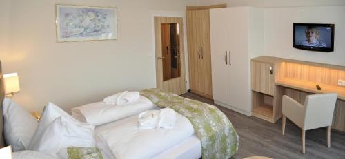 a hotel room with a white couch and a television at Hotel-Restaurant Grimmingblick in Bad Mitterndorf