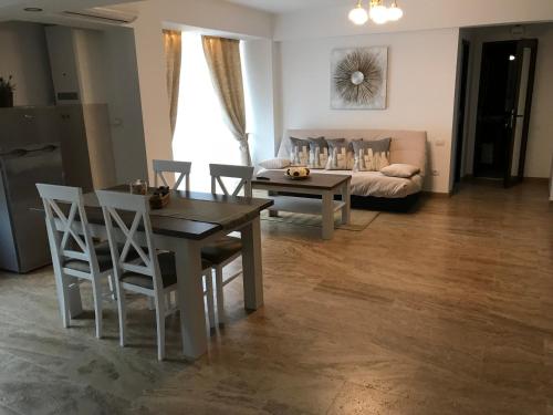 a living room with a table and chairs and a couch at apartament 2 camere ultracentral in Râmnicu Vâlcea