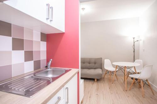 uma cozinha com um lavatório e uma mesa com uma cadeira em Appartement 3 - tout équipé - Carmes, Toulouse em Toulouse