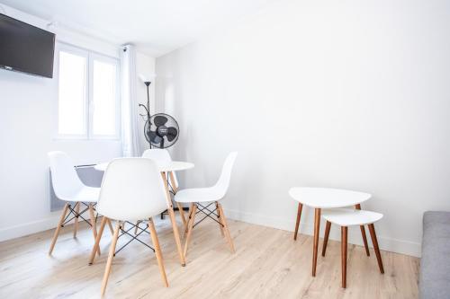 une salle à manger avec des chaises blanches et une table dans l'établissement Appartement 8 - tout équipé - Carmes, Toulouse, à Toulouse