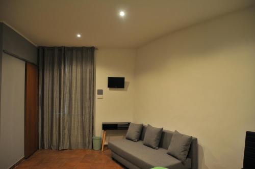 uma sala de estar com um sofá e uma televisão em Le Pignattelle B&B em Siena