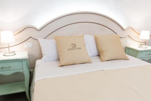 una camera da letto con un grande letto bianco con due comodini di Le Stanze Del Duomo a Lecce