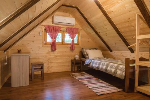 a bedroom with a bed in a log cabin at Kuća za odmor Cindrić in Slunj