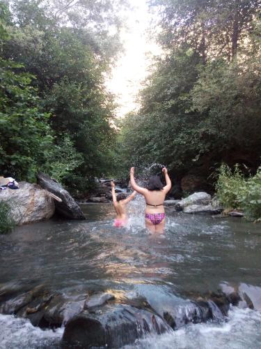 two people are standing in the water in a river at Hostal Pampaneira in Pampaneira