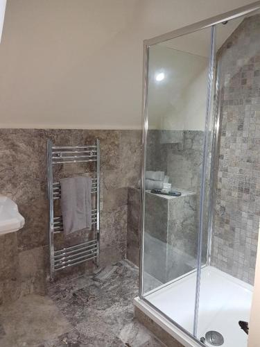 a bathroom with a shower with a glass door at Station House Lanark Bed and Breakfast in Lanark