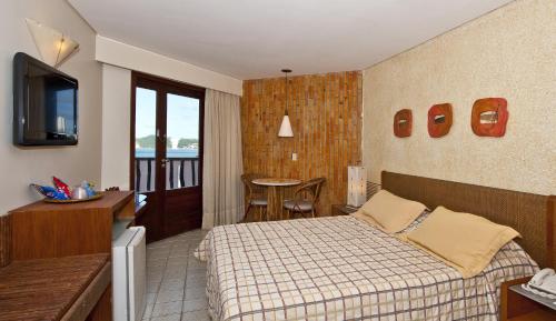 um quarto de hotel com uma cama e uma varanda em Rifoles Praia Hotel e Resort em Natal