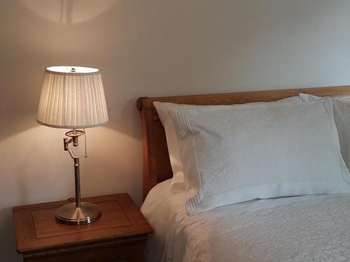 a lamp on a night stand next to a bed at Station House Lanark Bed and Breakfast in Lanark
