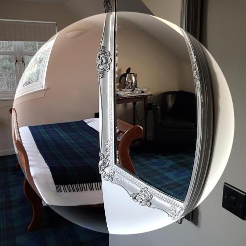 a room with a bed and a round mirror at Station House Lanark Bed and Breakfast in Lanark