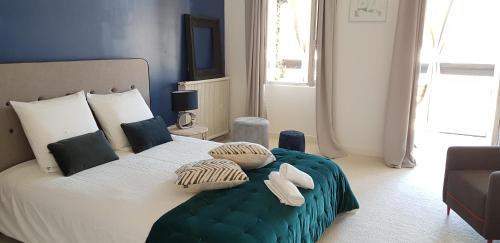 Un dormitorio con una cama grande con almohadas. en Le Particulier - Appart Hotel, en La Réole