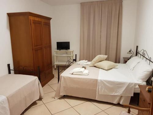 a bedroom with two beds and a television in it at Domus Elisa in San Cipriano Picentino