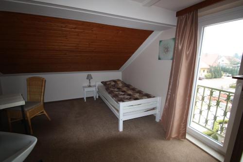 a white bed sitting in a room next to a window at Armarova Ihre Ferienpension in Cuxhaven