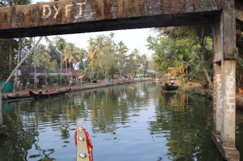 a boat in the water under a bridge at Marari houseboat in Mararikulam
