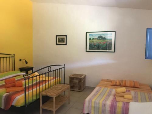 a bedroom with two twin beds and a chair at B&B Sa Tuerra in Teulada