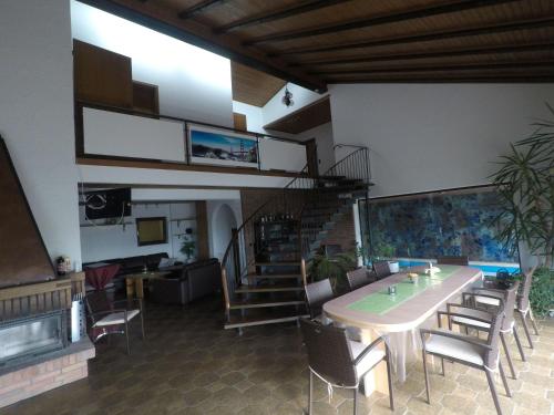 a room with a table and chairs and a staircase at Villa-Fuldablick in Morschen