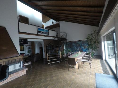 a room with a table and chairs and a spiral staircase at Villa-Fuldablick in Morschen