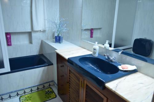 y baño con lavabo azul y espejo. en SEVILLA-TRIANA en Sevilla