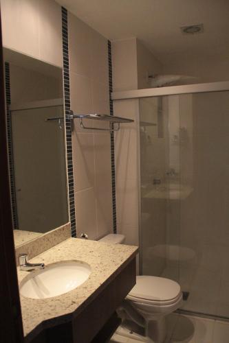 a bathroom with a toilet and a sink and a shower at Veredas do Rio Quente Flat in Rio Quente