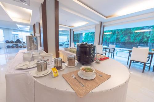 a white table with a bowl of soup on it at The Space Hotel SHA Plus in Chiang Rai