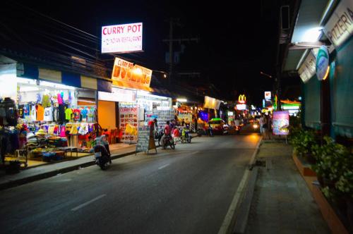 a city street at night with a lot of shops at Bonny Hotel 4 Floors No Elevator in Lamai
