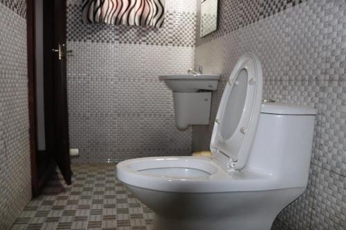 a bathroom with a white toilet and a sink at Marari houseboat in Mararikulam