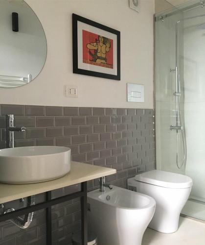 ein Badezimmer mit Waschbecken, Toilette und Spiegel in der Unterkunft BB Casamatta in Neapel