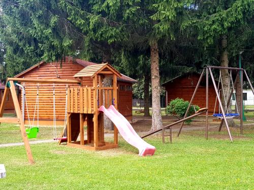 a playground with a slide and a play house at Apartamenty przy winnicach in Bogács