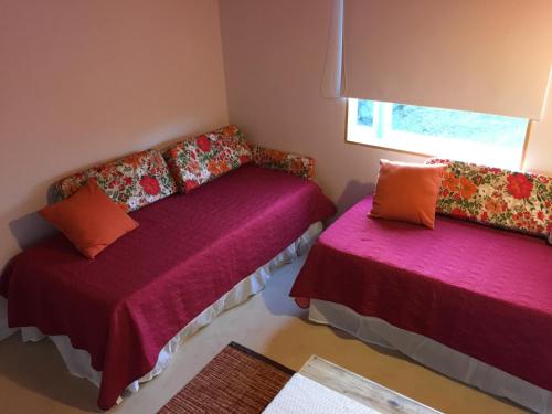 a small room with two beds and a window at Hostería La Soberana in El Calafate