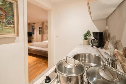 a kitchen with a sink and a bed in a room at Zur Schönen Aussicht Hotel garni in Garmisch-Partenkirchen