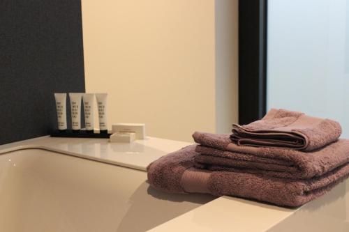 een stapel handdoeken op een aanrecht in een badkamer bij MAIO B&B en Dinner in Zonhoven