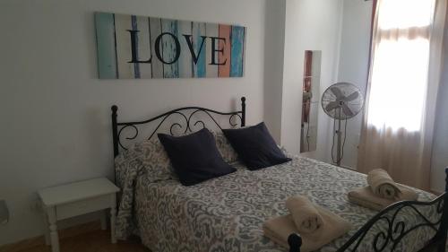 プラヤ・デ・ラス・アメリカスにあるViña del Marのベッドルーム1室(壁にラブサイン付きのベッド1台付)