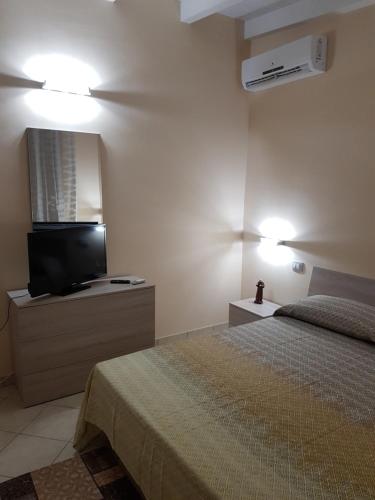 1 dormitorio con 1 cama y TV de pantalla plana en Casa Vacanze Preziosa, en Mazara del Vallo
