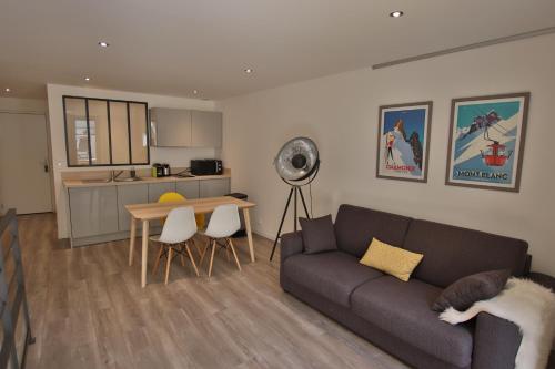 un salon avec un canapé et une table et une cuisine dans l'établissement Le 17 Faubourg, à Annecy