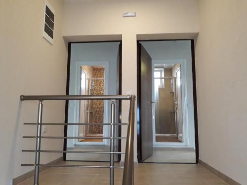 a hallway with two mirrors and a stair case at Vila & Apartments MATEA in Gevgelija