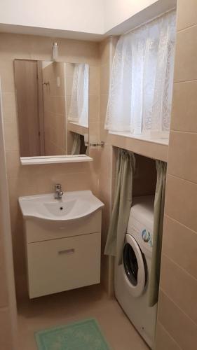 a bathroom with a sink and a washing machine at Monolocale II La Maddalena in La Maddalena