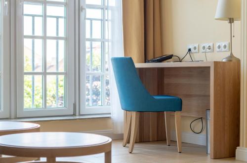 a blue chair sitting in front of a desk at Hotel Spiess & Spiess in Vienna