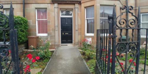 a black front door of a house with flowers at Mayfair Guest House in Edinburgh