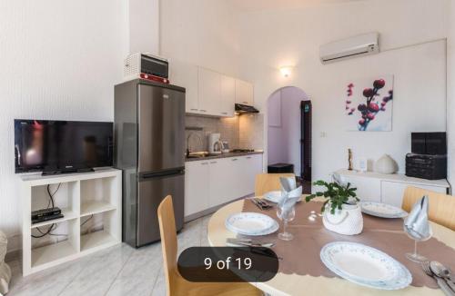 a kitchen and dining room with a table and a refrigerator at Apartmans Nadin in Umag
