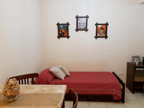 a bedroom with a red bed and a table at Depto. Centrico in Corrientes