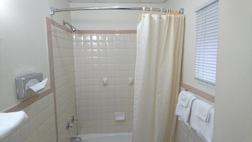 W łazience znajduje się prysznic z zasłoną prysznicową. w obiekcie Heritage Inn w mieście Uniontown