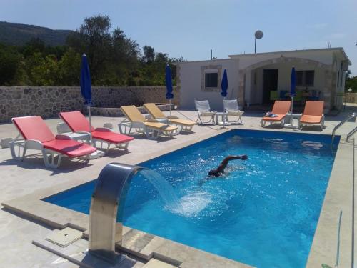 a person is swimming in a swimming pool at Vila Rogač in Tivat