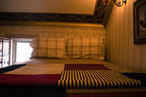 a bedroom with a bed with a plaid headboard and a window at Frisco Lodge in Frisco