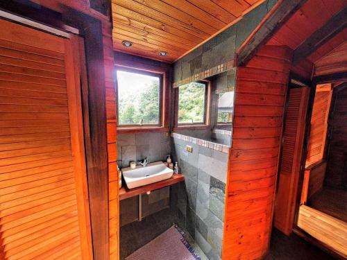 a bathroom with a sink and a window at Refugio Las Raices in Malalcahuello