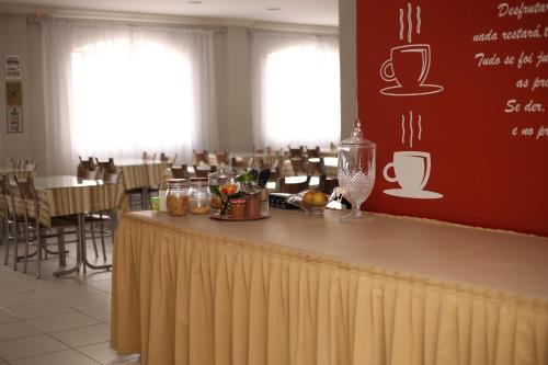 a bar in a restaurant with tables and chairs at Hotel Daieli in Otacílio Costa