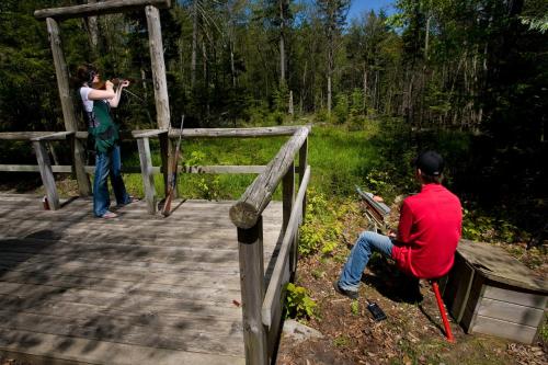 a woman taking a picture of a man on a wooden bridge at Inn at Snowshoe in Snowshoe