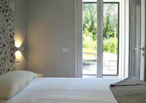 a bedroom with a white bed and a large window at A Casa Mia in Levanto