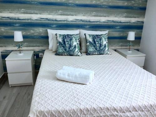 a bedroom with a white bed with two night stands at Flipflops Apartment in Nazaré