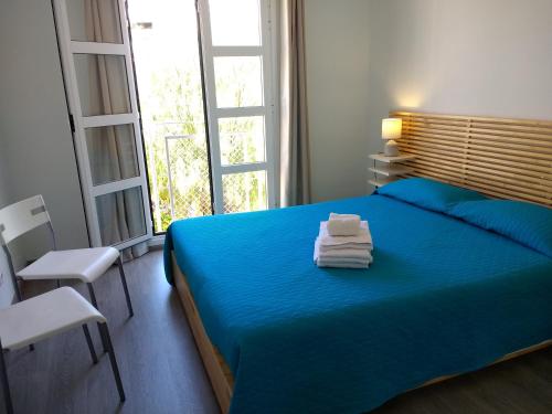 Un dormitorio con una cama azul con toallas. en Apartment Playa Torviscas, en Adeje