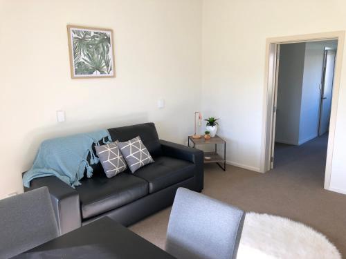 a living room with a black couch and a table at Otematata Escapes in Otematata