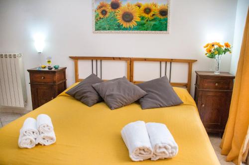 ナポリにあるB&B Carbonara Napoliのベッドルーム1室(黄色いベッド1台、タオル付)