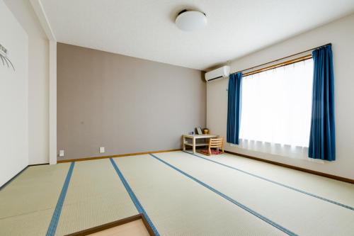 an empty living room with a large window at PLUS 9 Station INN in Izumi-Sano